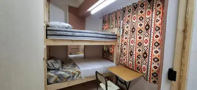 a room with two bunk beds and a table and a chair at david hostel in Aswan