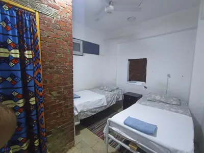 a room with two beds and a brick wall at david hostel in Aswan