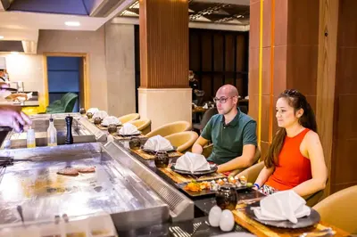 a man and a woman sitting at a table in a restaurant at Bellagio Beach Resort & Spa in Hurghada
