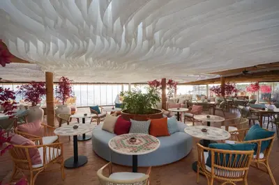 a restaurant with tables and chairs under a white ceiling at Desert Rose in Hurghada