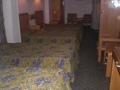 a hotel room with three beds and a table at Philippe Luxor Hotel in Luxor