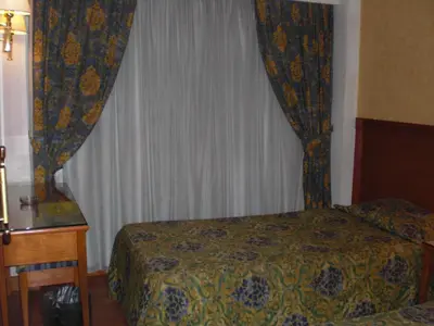 a bedroom with a bed and a window with curtains at Philippe Luxor Hotel in Luxor