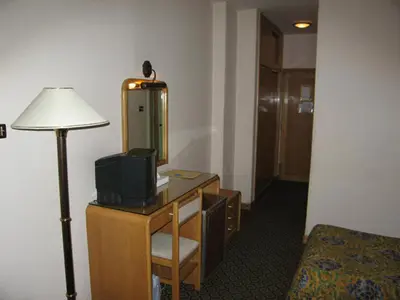 a hotel room with a desk with a television and a lamp at Philippe Luxor Hotel in Luxor