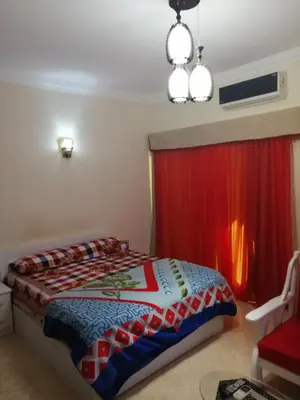 a bedroom with a bed and a red curtain at Nour Plaza Hurghada Studio Sea view in Hurghada