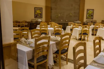 a dining room with white tables and chairs at Sky View Suites Hotel in Hurghada