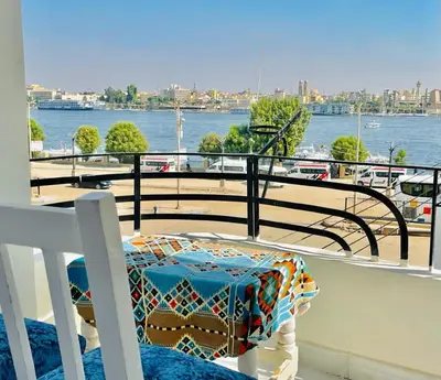 a table on a balcony with a view of the water at El Mesala Hotel in Luxor