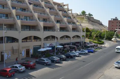 a large building with cars parked in a parking lot at The View Apartment in Hurghada