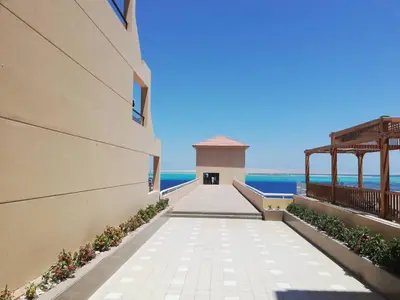 a walkway leading to the beach from a building at The View Apartment in Hurghada