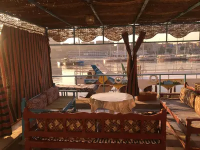 a room with benches and a table and a boat at Awi Guest House in Aswan
