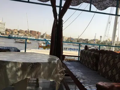 a table on a boat with a view of the water at Awi Guest House in Aswan