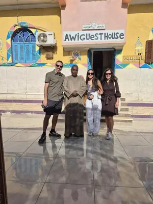 a group of people standing in front of a building at Awi Guest House in Aswan