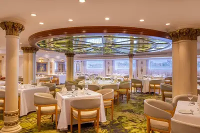 a restaurant with white tables and chairs and a ceiling at Sonesta St George Nile Cruise - Aswan to Luxor 3 Nights from Friday to Monday in Aswan