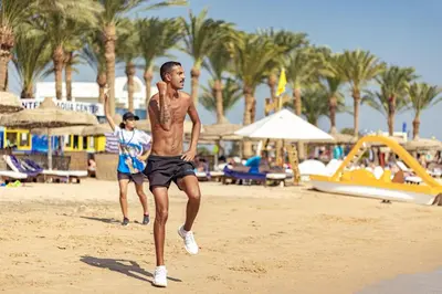 a man running on the beach near a playground at Palm Royale Resort - Soma Bay in Hurghada