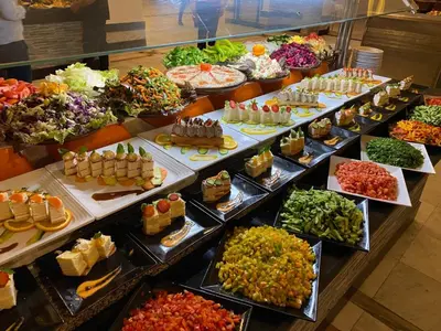 a buffet filled with lots of different types of food at Mirage Bay Resort & Aqua Park in Hurghada