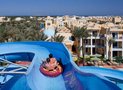 a child riding a water slide at a water park at Mirage Bay Resort & Aqua Park in Hurghada