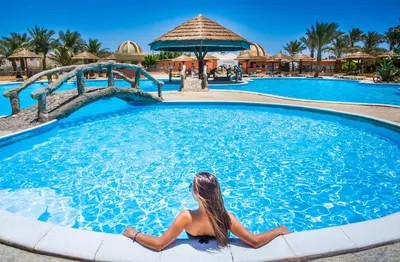 a woman sitting in a swimming pool at a resort at Seagull Beach Resort - Families and Couples Only in Hurghada