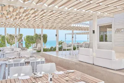 a patio with white furniture and a view of the ocean at Steigenberger Pure Lifestyle (Adults Only) in Hurghada