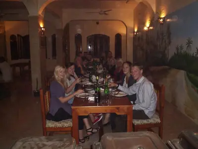 a group of people sitting around a table in a restaurant at Kareem Hotel Luxor in Luxor