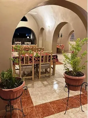 a dining room with a table and potted plants at Kareem Hotel Luxor in Luxor