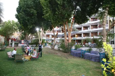 a group of people sitting in chairs in a park at Rezeiky Hotel & Camp 您在盧克索的第二個家 in Luxor