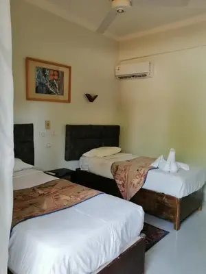 a hotel room with two beds in a room at Rezeiky Hotel & Camp 您在盧克索的第二個家 in Luxor