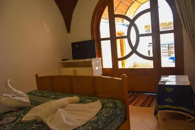 a bedroom with a bed and a large window at Villa Sunrise in Luxor