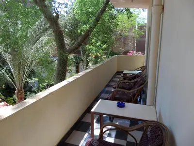 a balcony with chairs and a table and a window at Amon Hotel in Luxor