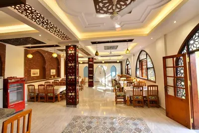 a dining room with tables and chairs and windows at Amon Hotel in Luxor