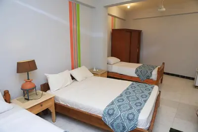 a bedroom with two beds and a lamp on a table at Amon Hotel in Luxor