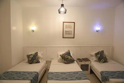 a room with two beds and a table and lights at Amon Hotel in Luxor