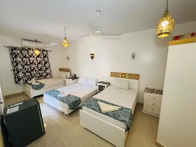 a living room with two beds and a couch at Amon Hotel in Luxor
