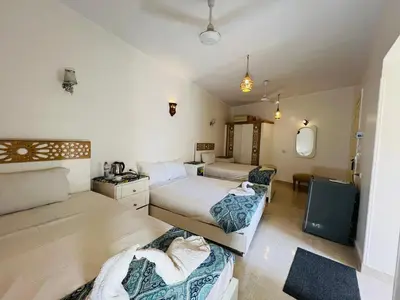a hotel room with two beds and a bathroom at Amon Hotel in Luxor
