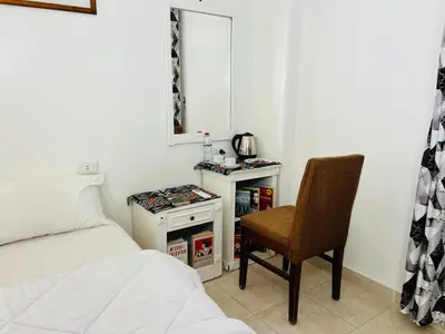 a bedroom with a bed and a chair and a mirror at Amon Hotel in Luxor
