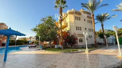 a large building with a swimming pool and palm trees at Green Garden Resort in Hurghada