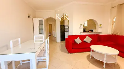 a living room with a red couch and a table at Green Garden Resort in Hurghada