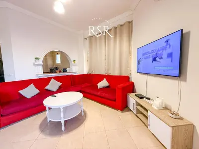 a living room with a red couch and a tv at Green Garden Resort in Hurghada