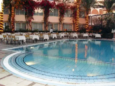 a swimming pool in front of a hotel with tables and chairs at Sea Garden Hotel in Hurghada