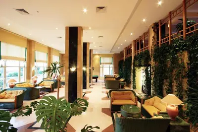 a lobby with couches and plants in a building at Sea Garden Hotel in Hurghada