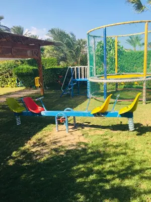 a group of different colored playground equipment in the grass at Sea Star Beau Rivage Hotel in Hurghada