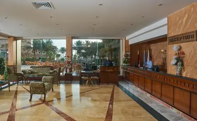 a lobby of a hotel with tables and chairs at Sea Star Beau Rivage Hotel in Hurghada