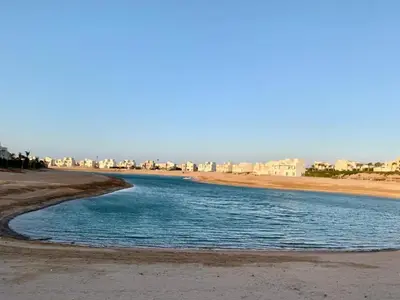 a river on the beach with buildings in the background at Joubal Apartment in Hurghada