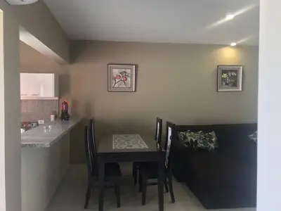 a dining room with a table and a kitchen at Joubal Apartment in Hurghada