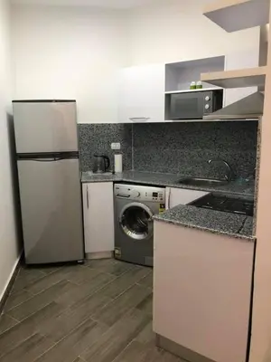 a kitchen with a refrigerator and a washing machine at Joubal Apartment in Hurghada