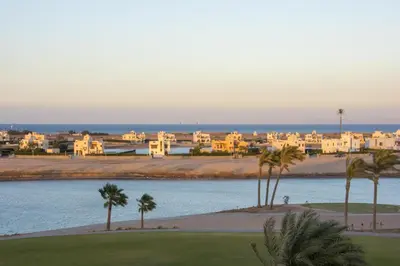 a view of a beach with palm trees and buildings at Joubal Apartment in Hurghada