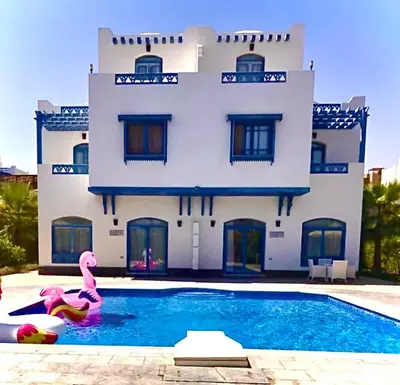 a building with a swimming pool in front of a house at Luxury Villa with pool in Hurghada in Hurghada