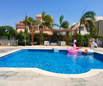 a swimming pool with two inflatable flamingos in it at Luxury Villa with pool in Hurghada in Hurghada