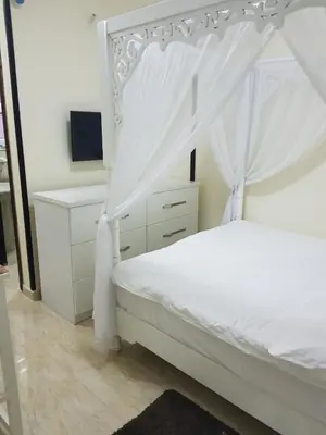 a bedroom with a white canopy bed and a desk at Tiba Resort Hurghada in Hurghada