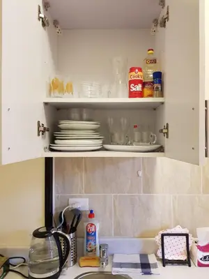 a kitchen cabinet with plates and dishes in it at Tiba Resort Hurghada in Hurghada
