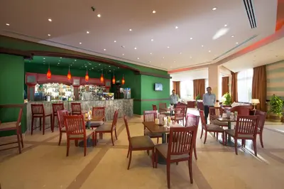 a restaurant with wooden tables and chairs and a bar at Concorde Moreen Beach Resort in Abu Dabab