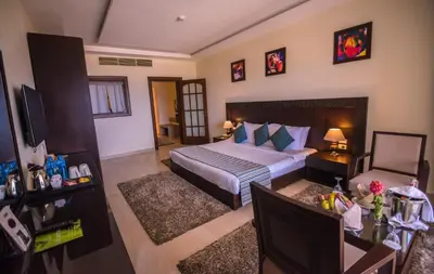 a bedroom with a bed and a desk and a television at Concorde Moreen Beach Resort in Abu Dabab